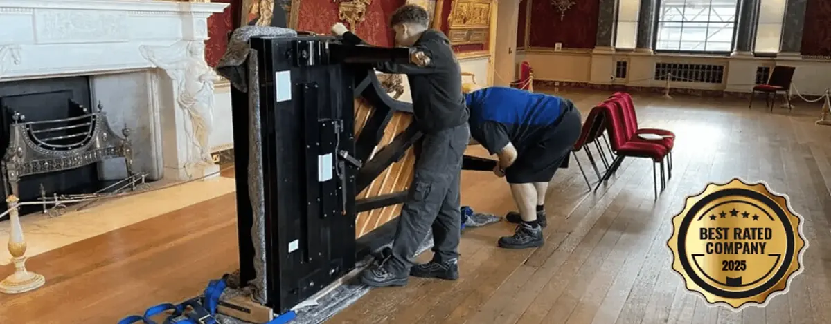 Specialist team manoeuvring a grand piano in a formal hall, grand piano removals across West Yorkshire